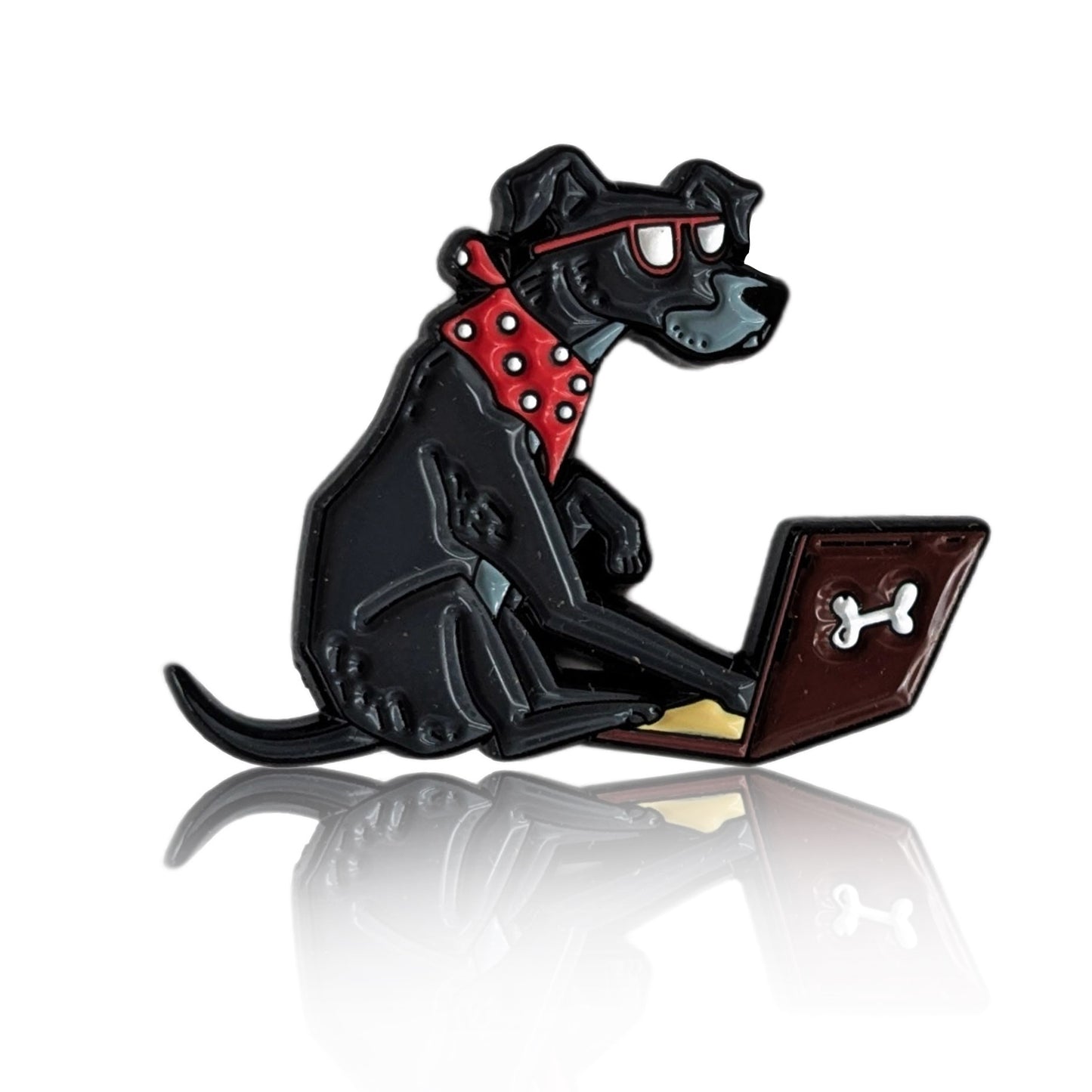 Enamel pin of a cartoon black dog with glasses using a laptop, wearing a red bandana