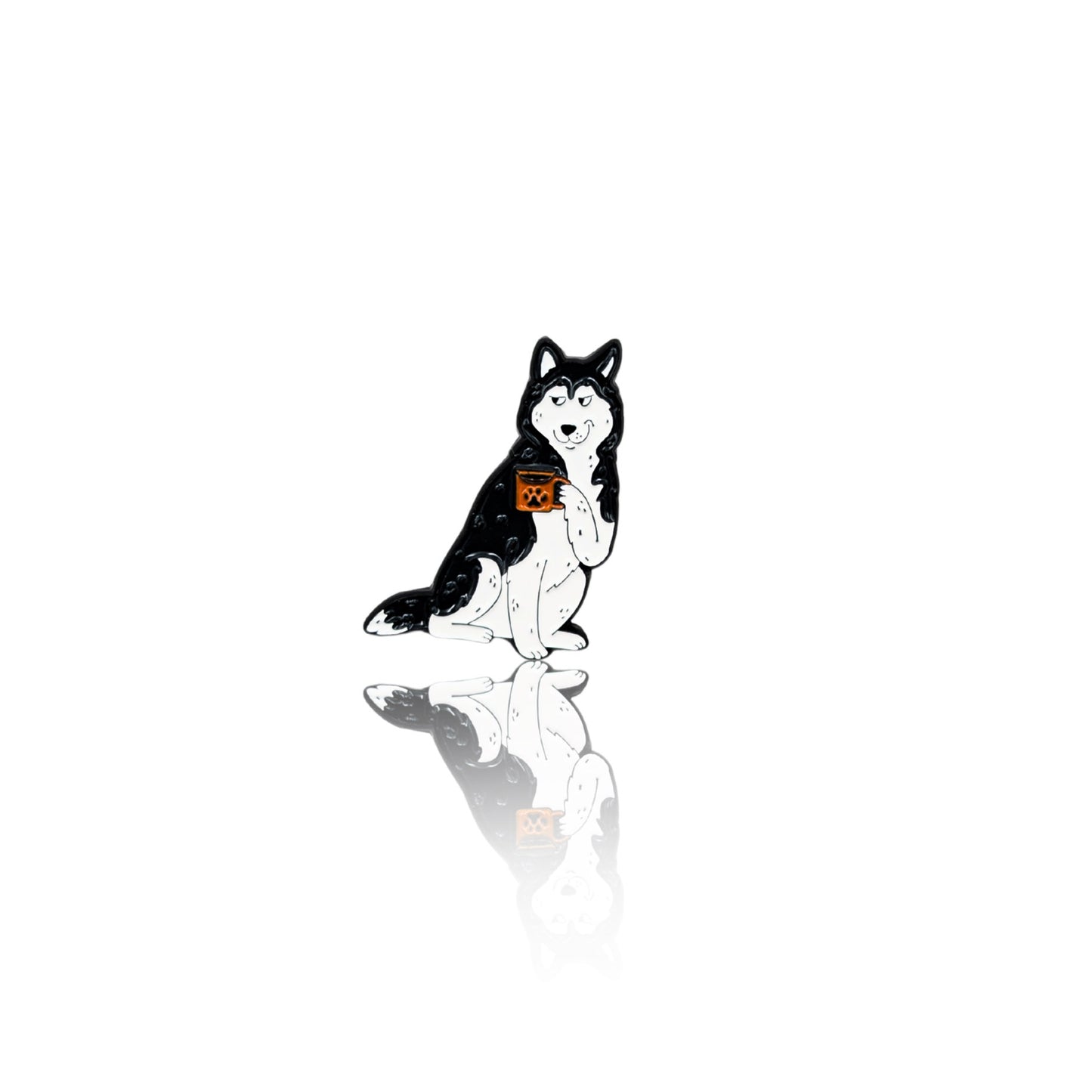 Enamel pin of a black-and-white Husky sitting and holding a coffee mug with a relaxed expression. The pin has a glossy finish with a reflection on a white background, making it a fun accessory for coffee and dog lovers.
