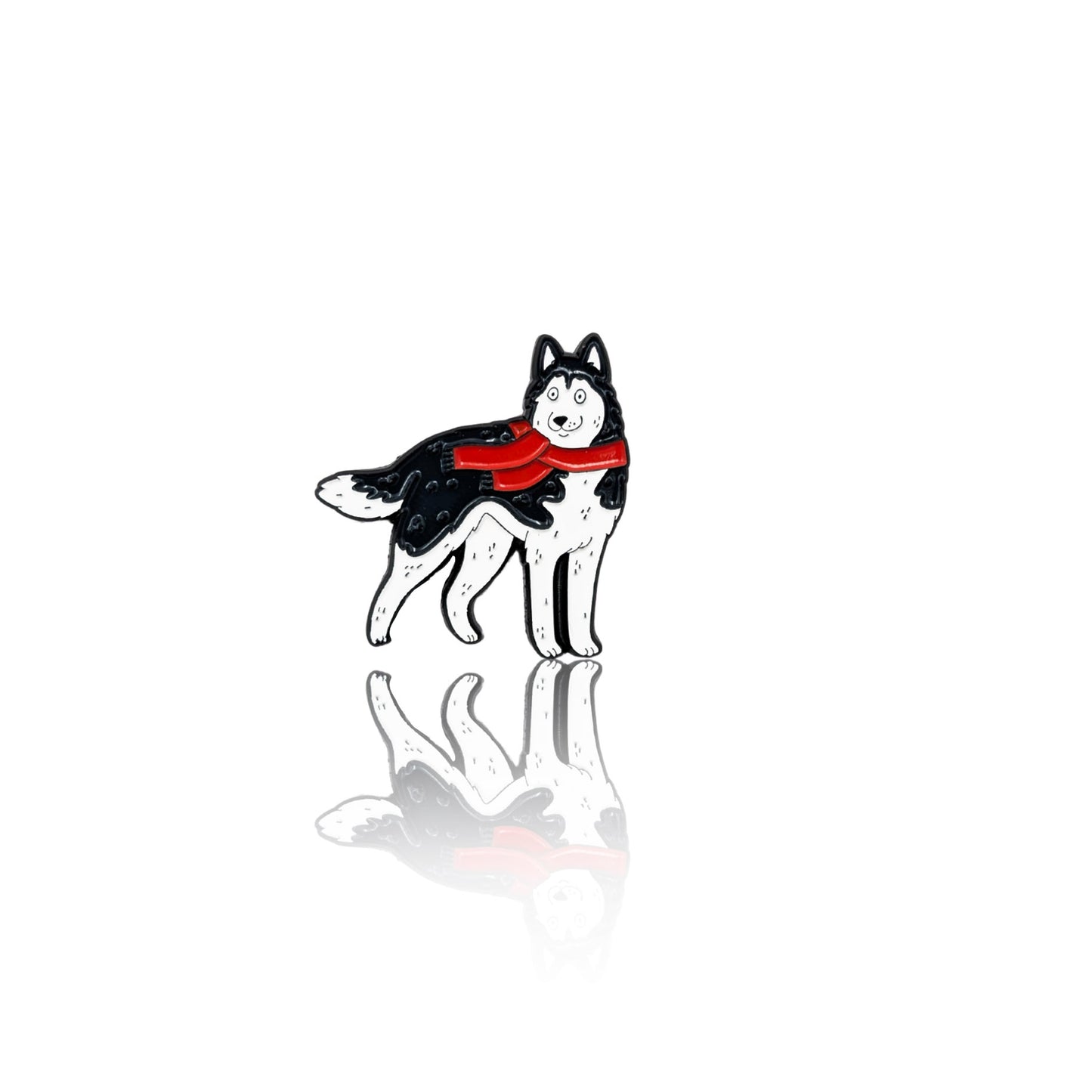 Enamel pin of a black-and-white Husky wearing a red scarf, standing confidently. The pin has a glossy finish with a reflection on a white background, making it a great winter-themed accessory for dog lovers.