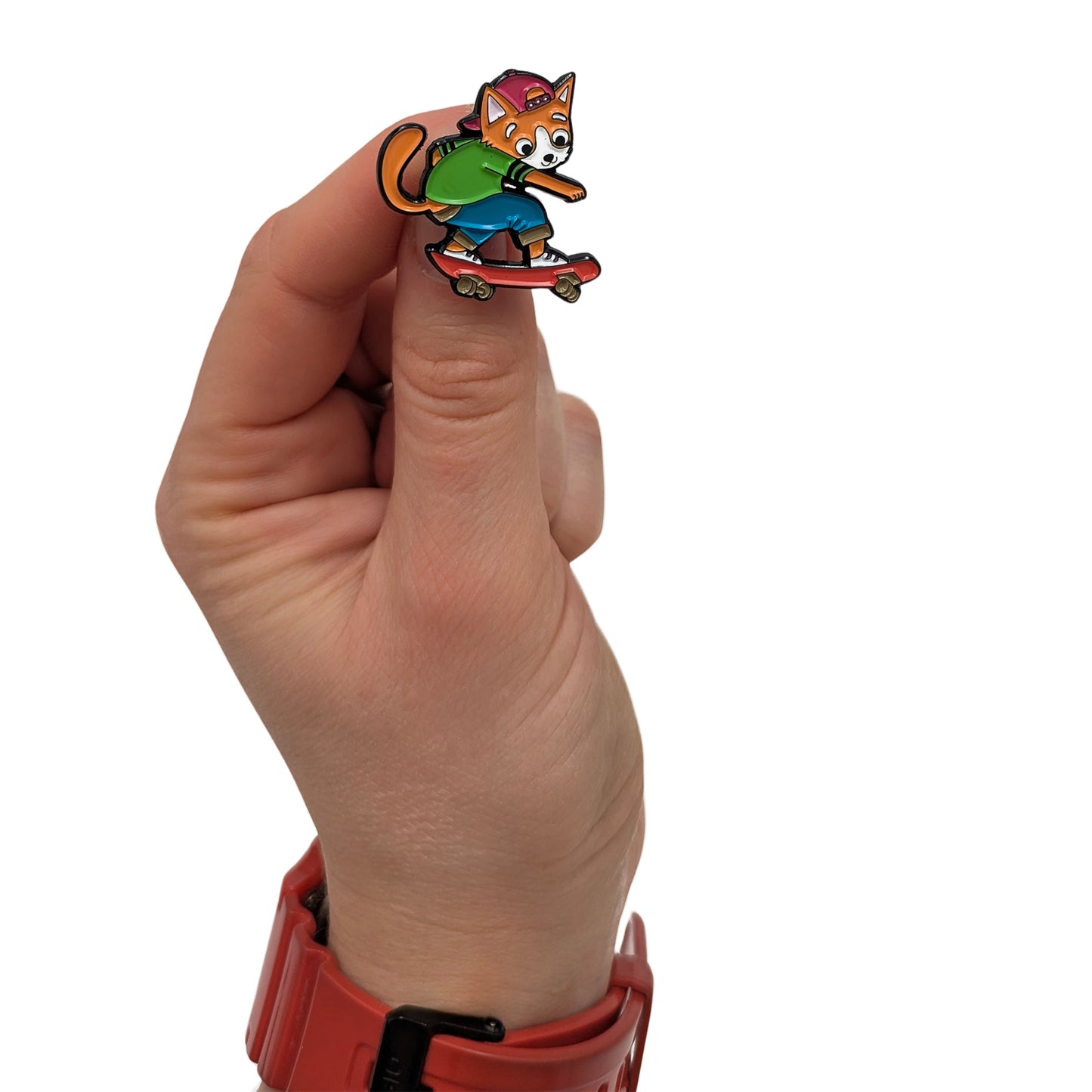 Kickflip Cat Milo enamel pin held in hand, showing a cat riding a skateboard with a backwards cap