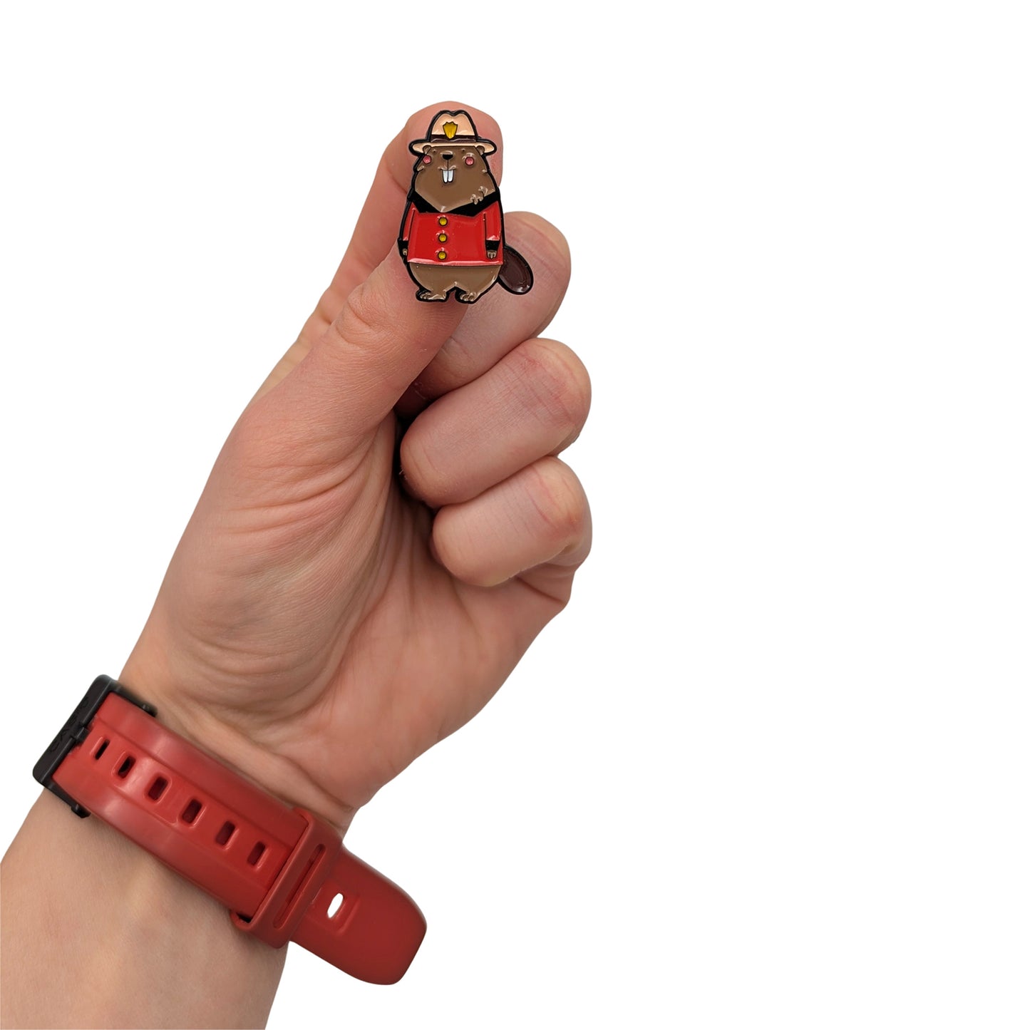 Beaver enamel pin dressed in a Canadian Mountie uniform, held in hand, featuring a red jacket and hat