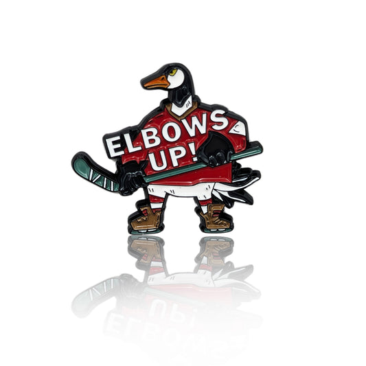 Enamel pin of a Canada goose in a red hockey jersey holding a stick with the words "Elbows Up!"