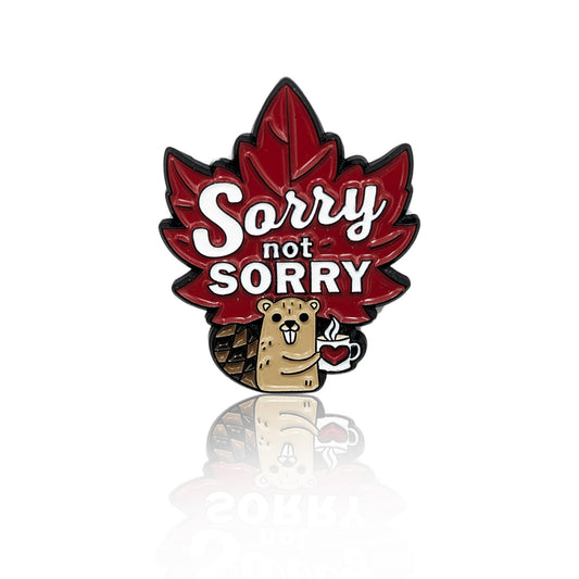 Enamel pin shaped like a red maple leaf with the words "Sorry not Sorry" and a cartoon beaver holding coffee