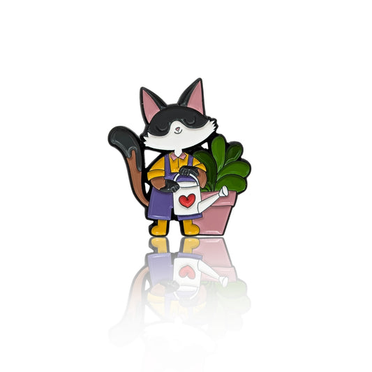 Cat enamel pin with watering can and potted plant, shown on a clean white background