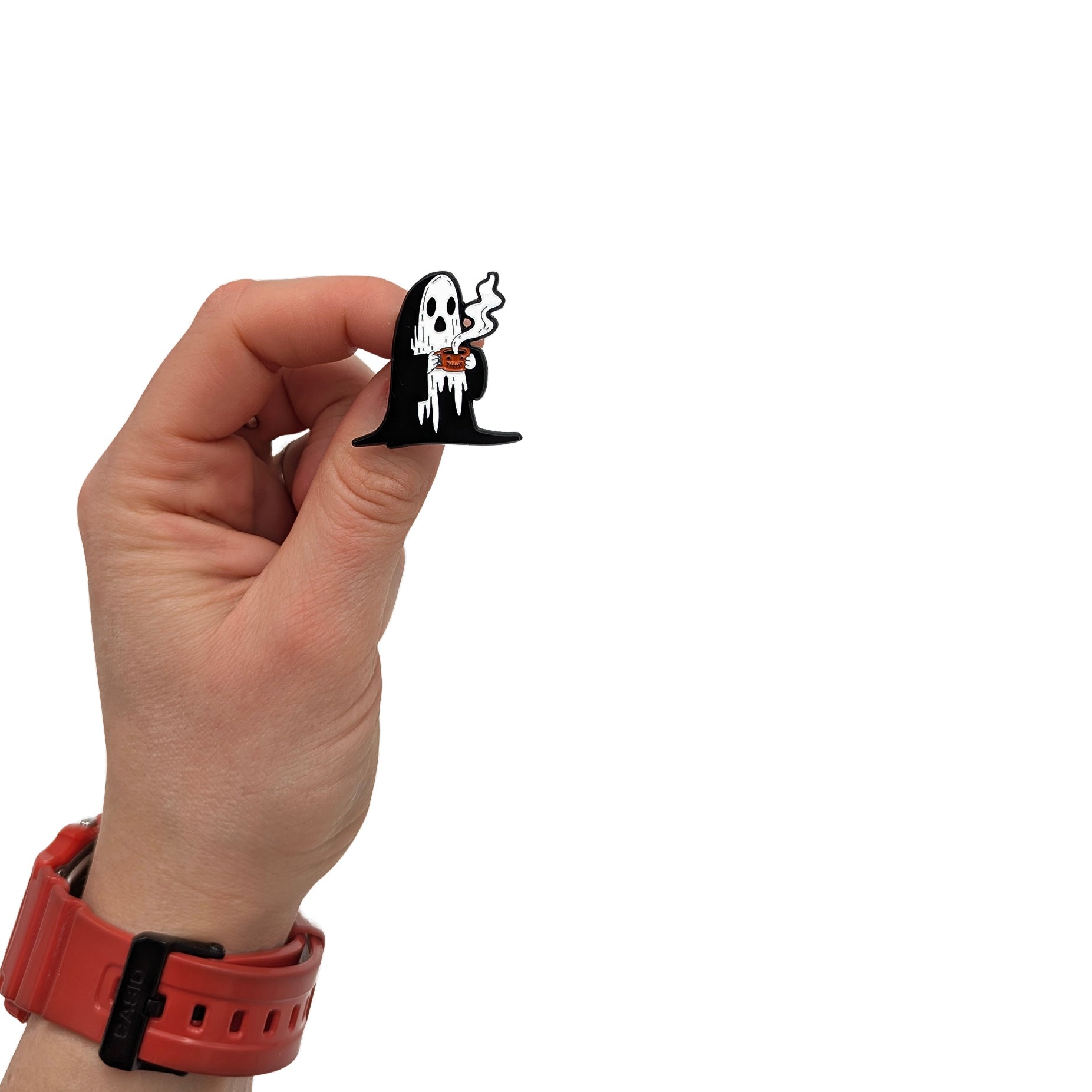 Ghost enamel pin held in hand, showing a white ghost in a black cloak holding a steaming coffee cup
