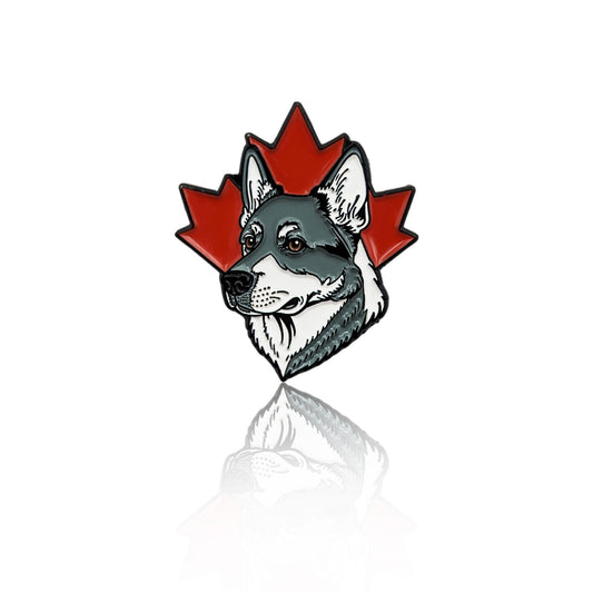 hand holding grey and white husky dog enamel pin with red maple leaf background
