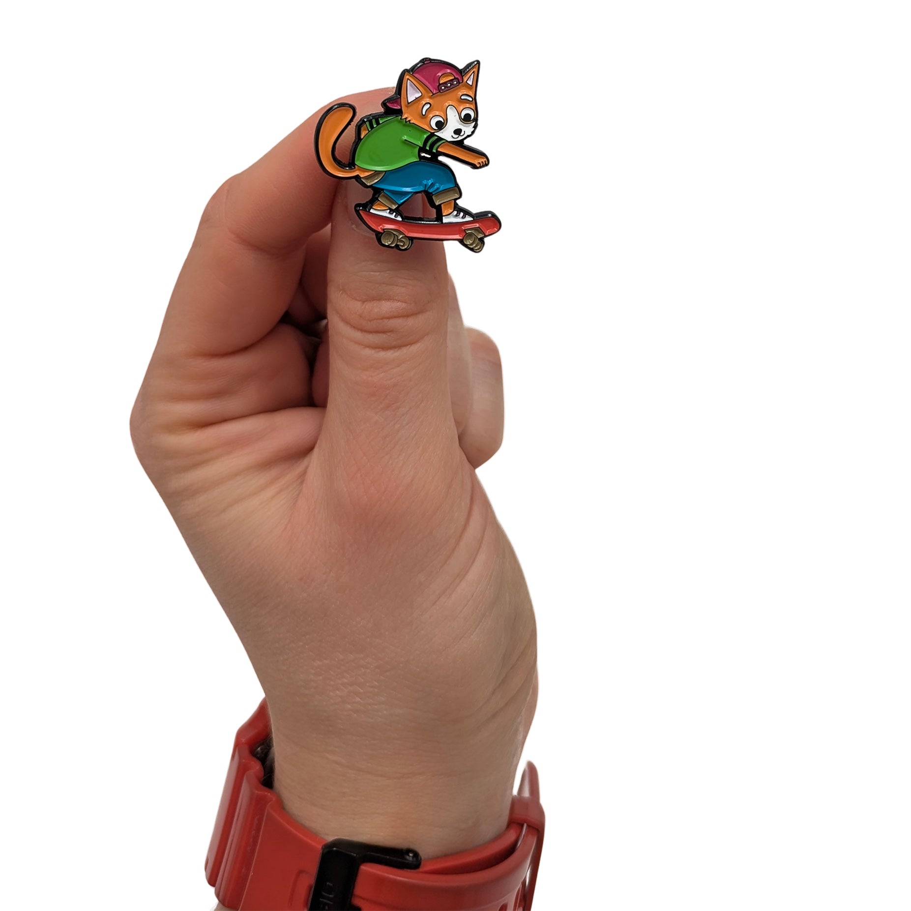 Kickflip Cat Milo enamel pin held in hand, showing a cat riding a skateboard with a backwards cap