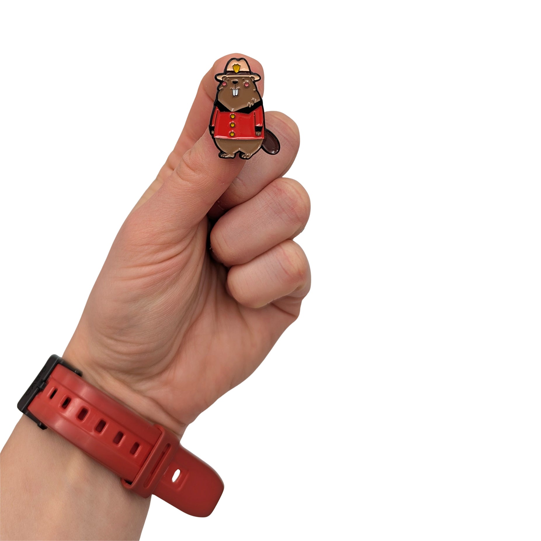 Beaver enamel pin dressed in a Canadian Mountie uniform, held in hand, featuring a red jacket and hat