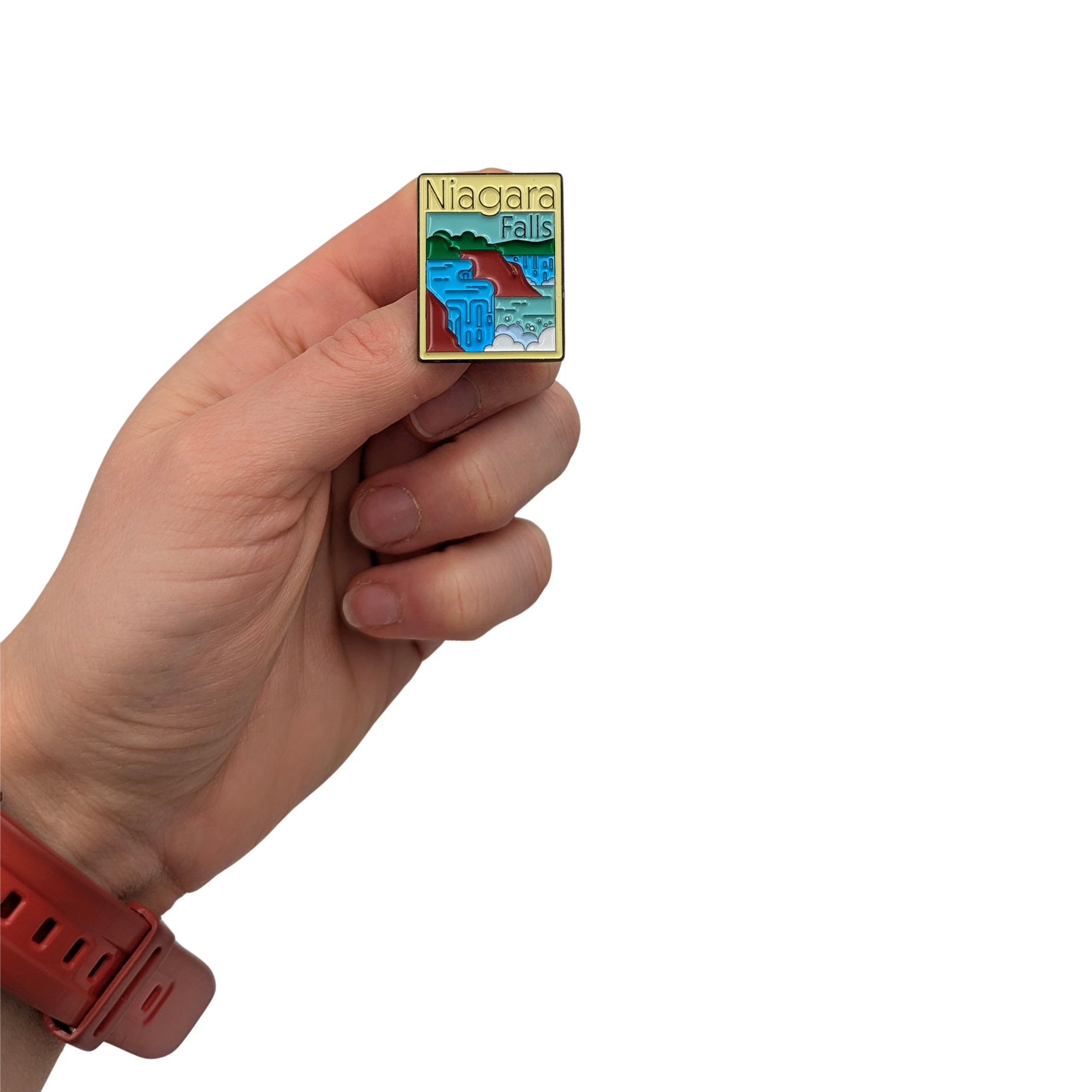 Niagara Falls enamel pin held in hand, featuring a colorful graphic illustration of the iconic waterfall