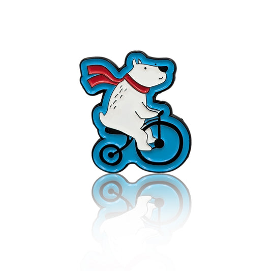 Polar Pedal Pete enamel pin showing a polar bear riding a bicycle, winter cycling character pin on white background